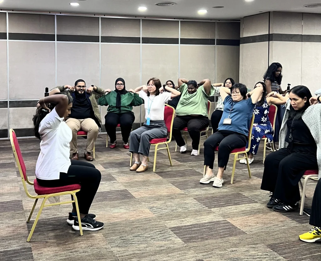 Employees participating in a guided wellness and stretching session during International Women’s Day 2026 at QI Group