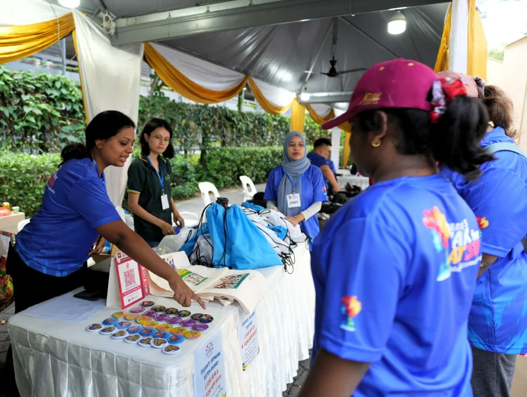 One of the Taarana teachers is explaining the children's artwork, which was turned into badges and bags.