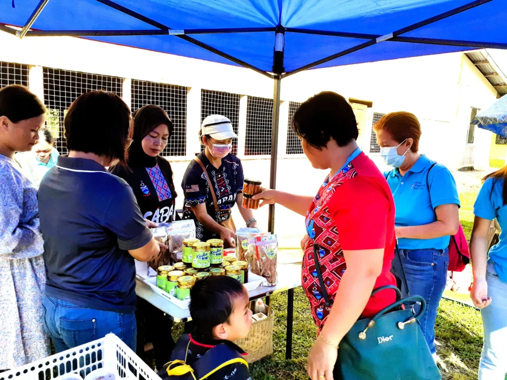 Community members showcase locally produced goods during a RYTHM Foundation Community Adoption Programme activity in Sabah.