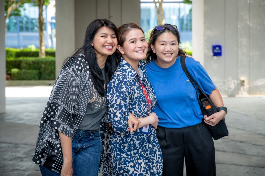 Employees pose with refill purchases and plants from the Taarana School sale during QI Group's Plastic Free July sustainability initiative at QI Tower.